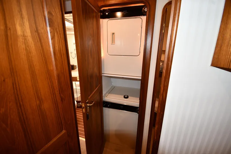 Slide: The Image of Laundry area inside 1996 Ocean Yachts 53 Super Sport, featuring wood paneling and appliances. - 38