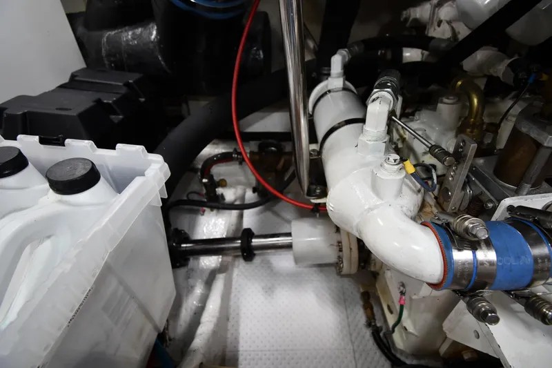 Slide: The Image of Engine room of a 1996 Ocean Yachts 53 Super Sport, showcasing mechanical components and hoses. - 69