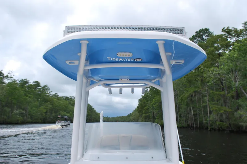 Slide: The Image of 2021 Tidewater 210 CC Adventure boat cruising on a scenic river. - 6