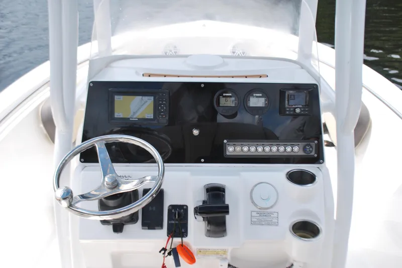 Slide: The Image of 2021 Tidewater 210 CC Adventure boat dashboard with steering wheel and navigation controls. - 7