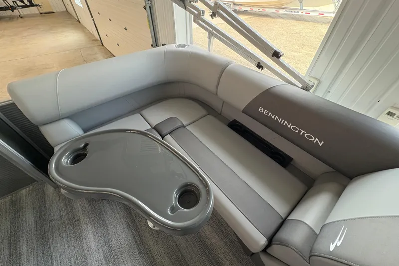 Slide: The Image of 2026 Bennington 168 SL Electric boat interior with gray seating and cupholder table. - 11