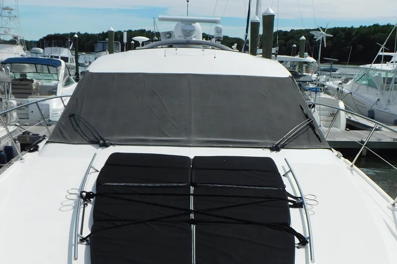 Slide: The Image of 2013 Sea Ray 510 Sundancer yacht docked at marina, featuring covered windshield and sunpad. - 10