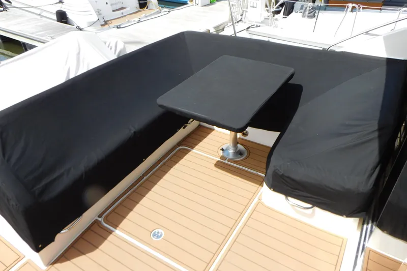 Slide: The Image of 2013 Sea Ray 510 Sundancer deck with black-covered seating and table. - 15