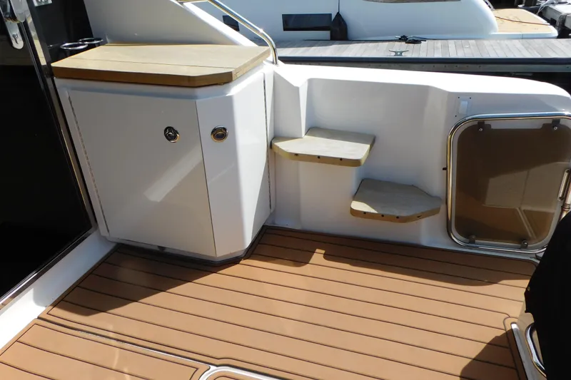 Slide: The Image of 2013 Sea Ray 510 Sundancer yacht deck with wooden steps and storage cabinet. - 17