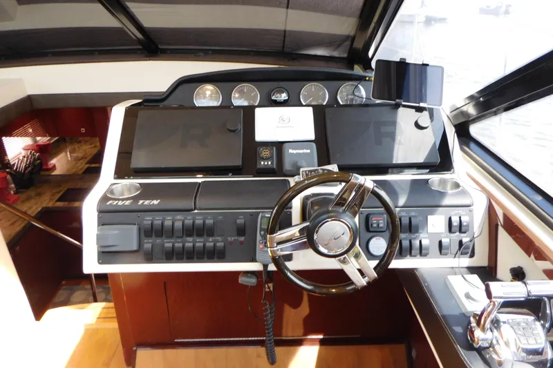 Slide: The Image of 2013 Sea Ray 510 Sundancer helm with modern controls and navigation equipment. - 33