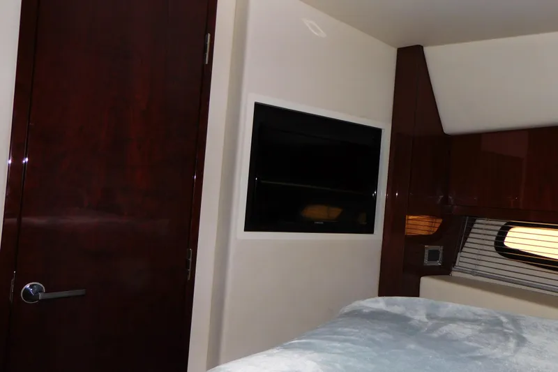 Slide: The Image of Interior of 2013 Sea Ray 510 Sundancer with TV, wooden door, and window blinds. - 55