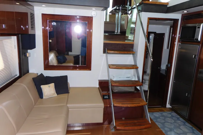 Slide: The Image of Interior of 2013 Sea Ray 510 Sundancer yacht with modern furnishings and wooden staircase. - 57