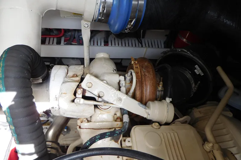 Slide: The Image of Engine compartment of a 2013 Sea Ray 510 Sundancer, showcasing mechanical components and hoses. - 85