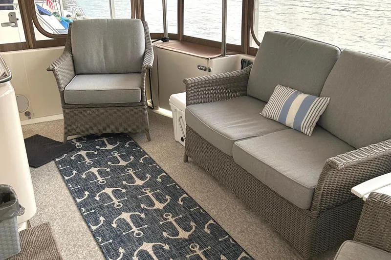 Slide: The Image of Interior of 2001 Sea Ray 420 Aft Cabin with wicker furniture and nautical-themed decor. - 10