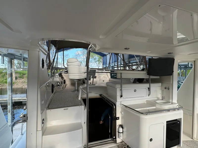 Slide: The Image of 2001 Sea Ray 420 Aft Cabin interior with helm, seating, and kitchenette. - 13