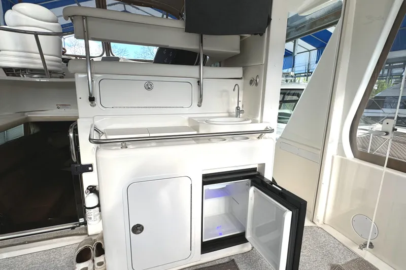 Slide: The Image of 2001 Sea Ray 420 Aft Cabin yacht interior with kitchenette and open mini fridge. - 15