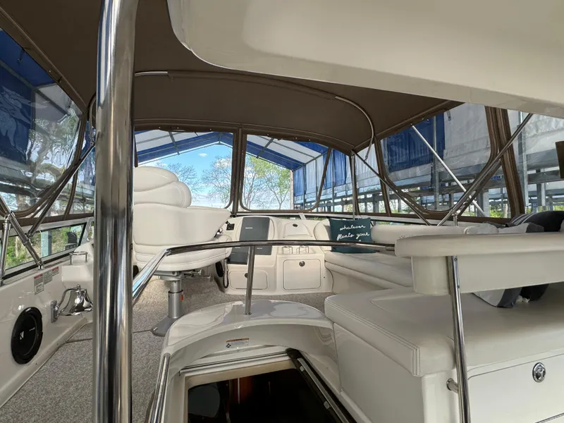 Slide: The Image of 2001 Sea Ray 420 Aft Cabin interior with seating and helm under canopy. - 16