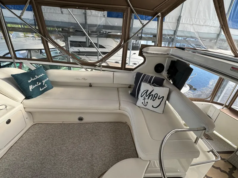 Slide: The Image of 2001 Sea Ray 420 Aft Cabin interior with cozy seating and nautical-themed pillows. - 17