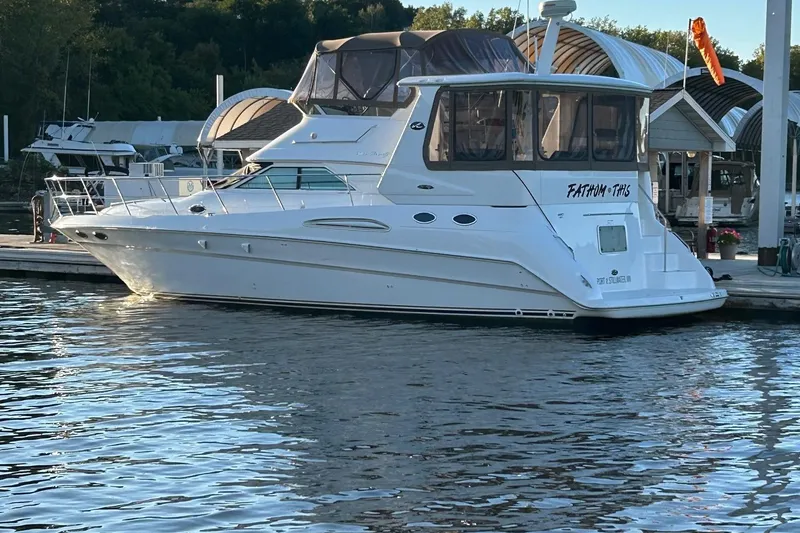 Slide: The Image of 2001 Sea Ray 420 Aft Cabin yacht docked at marina, reflecting on calm water. - 2
