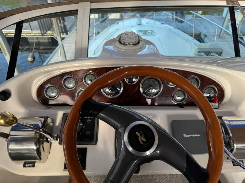 Slide: The Image of 2001 Sea Ray 420 Aft Cabin helm with gauges and wooden steering wheel. - 23