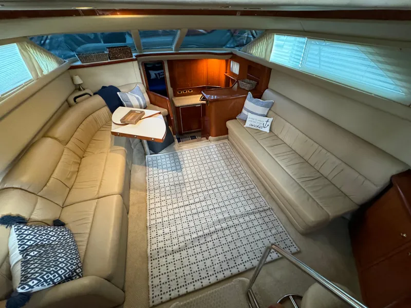 Slide: The Image of Interior of 2001 Sea Ray 420 Aft Cabin with beige seating and wooden cabinetry. - 32
