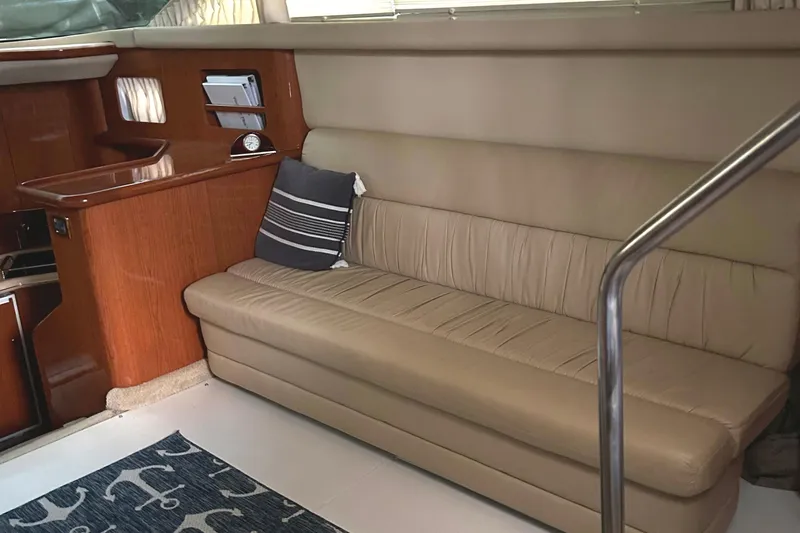 Slide: The Image of 2001 Sea Ray 420 Aft Cabin interior with beige leather sofa and wooden accents. - 34