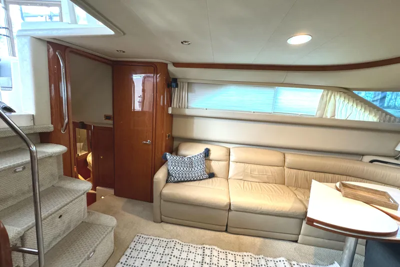 Slide: The Image of Interior of 2001 Sea Ray 420 Aft Cabin with beige sofa and wooden accents. - 36