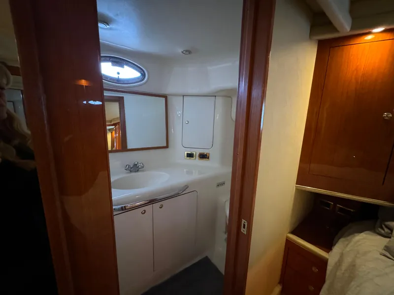 Slide: The Image of 2001 Sea Ray 420 Aft Cabin bathroom with sink, mirror, and wooden cabinetry. - 44
