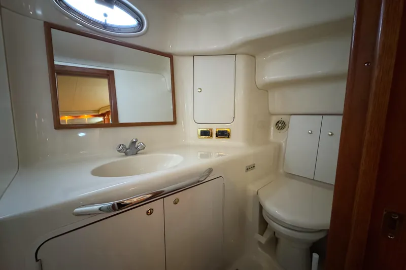 Slide: The Image of 2001 Sea Ray 420 Aft Cabin bathroom with sink, mirror, and storage cabinets. - 45