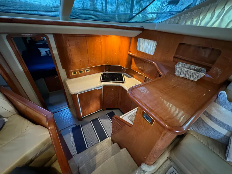 Slide: The Image of 2001 Sea Ray 420 Aft Cabin interior with wood cabinetry and compact kitchen area. - 47