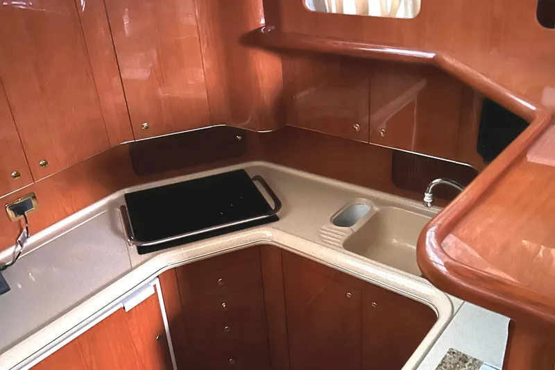 Slide: The Image of 2001 Sea Ray 420 Aft Cabin kitchen with wood cabinetry and modern sink. - 49