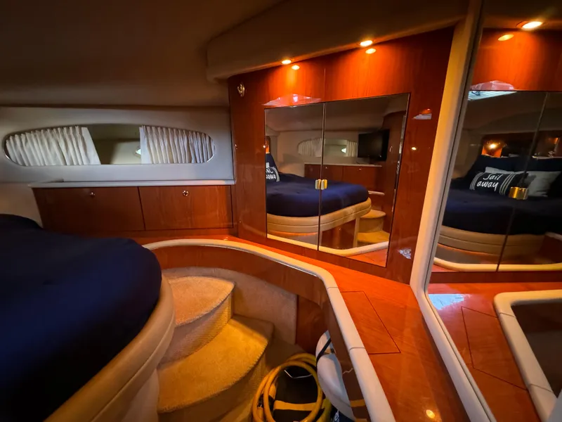 Slide: The Image of Luxurious 2001 Sea Ray 420 Aft Cabin interior with elegant wood finishes and cozy bedding. - 54
