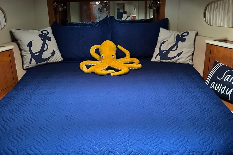 Slide: The Image of Cozy cabin interior of 2001 Sea Ray 420 Aft, featuring nautical-themed bedding. - 56