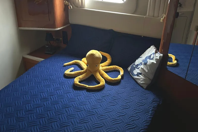 Slide: The Image of 2001 Sea Ray 420 Aft Cabin bedroom with blue bedding and yellow octopus plush. - 57