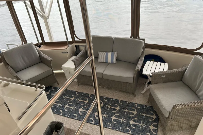 Slide: The Image of 2001 Sea Ray 420 Aft Cabin interior with wicker seating and nautical decor. - 8