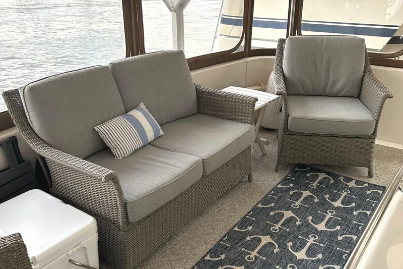 Slide: The Image of Cozy seating area on 2001 Sea Ray 420 Aft Cabin with wicker furniture and nautical decor. - 9