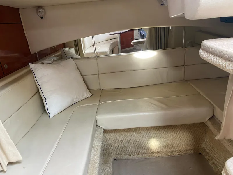 Slide: The Image of Interior cabin of 2005 Sea Ray 300 Sundancer with beige seating and pillow. - 16