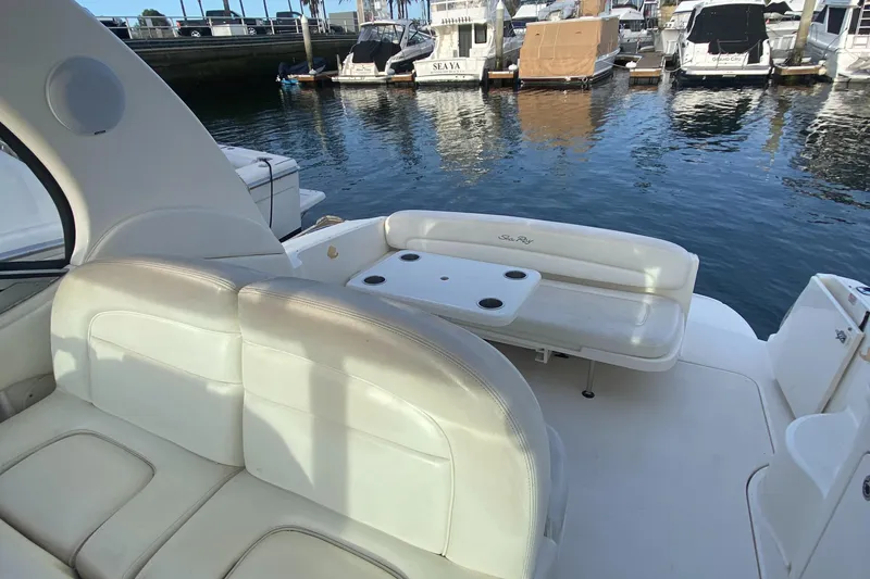 Slide: The Image of 2005 Sea Ray 300 Sundancer boat interior with seating and table, docked at marina. - 4