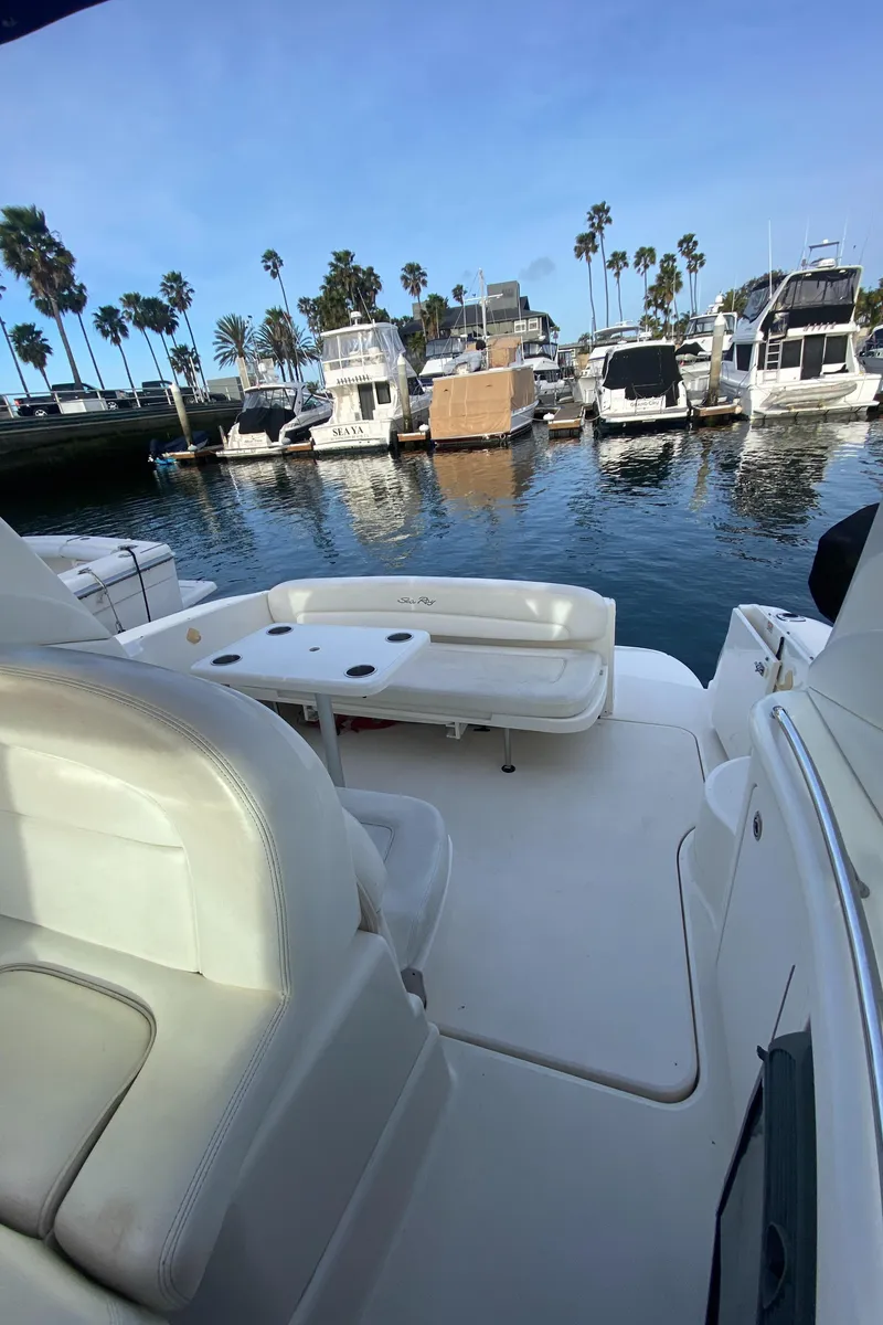 Slide: The Image of 2005 Sea Ray 300 Sundancer at marina, surrounded by palm trees and boats. - 6