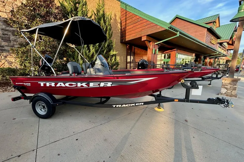 The Image of 2026 Tracker Super Guide V-16 SC boat on trailer outside a store. - 0