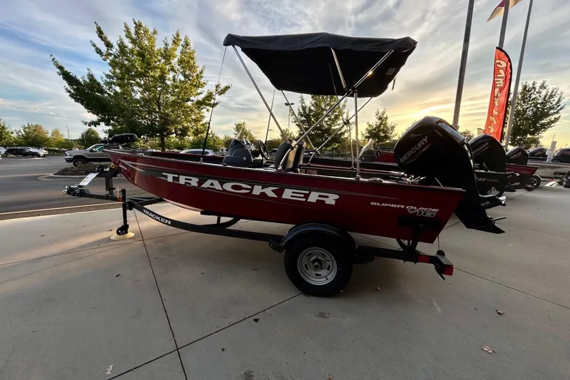Slide: The Image of 2026 Tracker Super Guide V-16 SC boat on trailer, parked outdoors at sunset. - 2