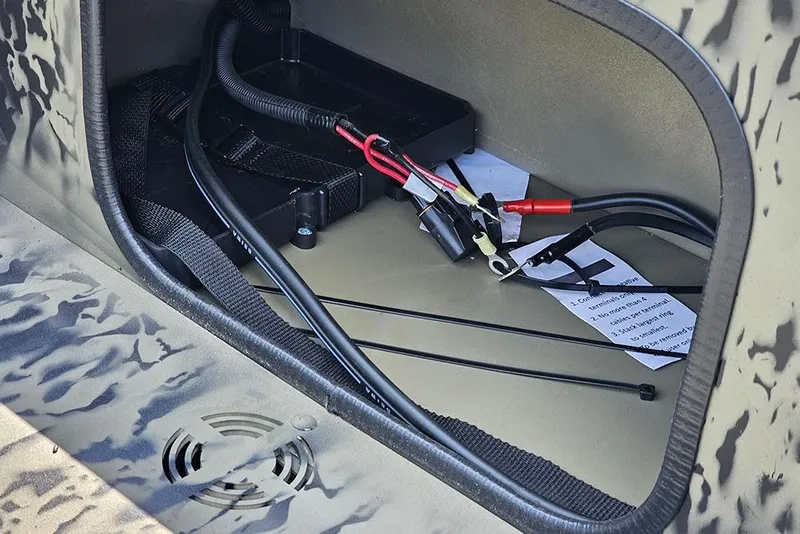 Slide: The Image of 2026 Tracker Grizzly 1654 T Sportsman boat compartment with wiring and instructions. - 13