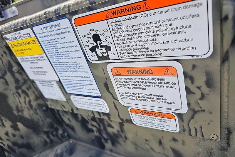 Slide: The Image of Warning labels on 2026 Tracker Grizzly 1654 T Sportsman boat, highlighting safety precautions. - 14