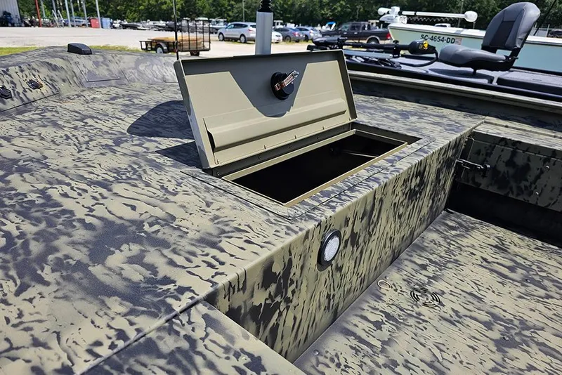 Slide: The Image of 2026 Tracker Grizzly 1654 T Sportsman boat with open storage compartment, camo design. - 16