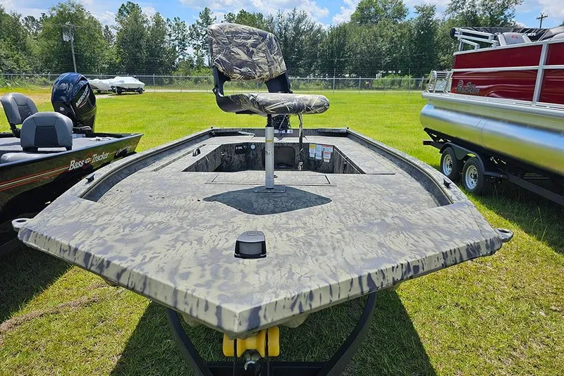 Slide: The Image of 2026 Tracker Grizzly 1654 T Sportsman boat with camo seat on grassy field. - 4