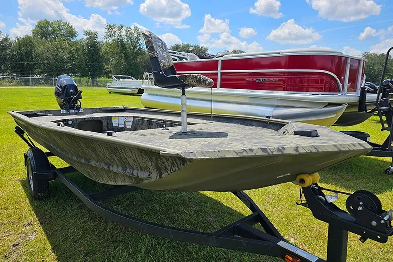 Slide: The Image of 2026 Tracker Grizzly 1654 T Sportsman boat on trailer, displayed outdoors. - 5