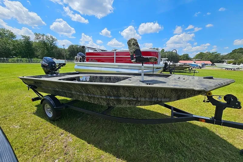 Slide: The Image of 2026 Tracker Grizzly 1654 T Sportsman boat on trailer, parked on grassy field under blue sky. - 6