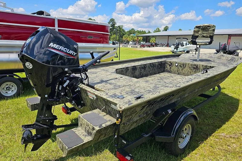Slide: The Image of 2026 Tracker Grizzly 1654 T Sportsman boat with Mercury engine on grassy field. - 7