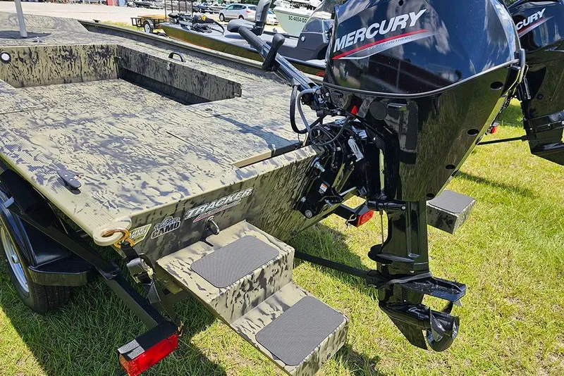 Slide: The Image of 2026 Tracker Grizzly 1654 T Sportsman boat with Mercury outboard motor on grass. - 9