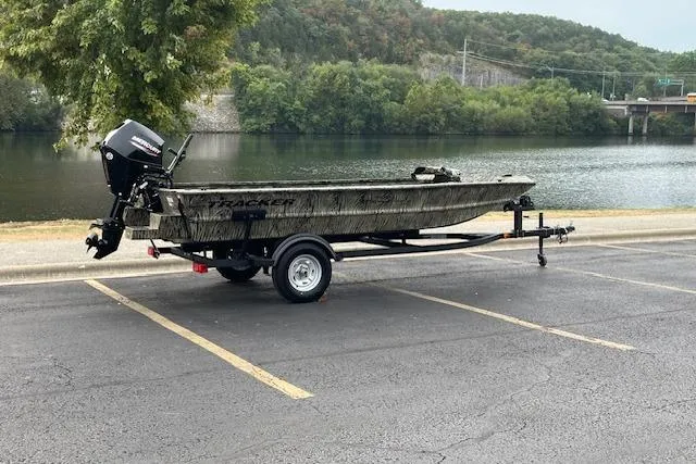 Slide: The Image of 2026 Tracker Grizzly 1654 T Sportsman boat on trailer, camo design, Mercury outboard motor. - 2