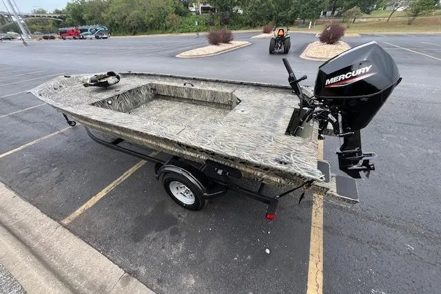 Slide: The Image of 2026 Tracker Grizzly 1654 T Sportsman boat on trailer, camo design, parked outdoors. - 4