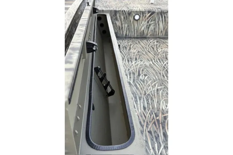 Slide: The Image of 2026 Tracker Grizzly 1654 T Sportsman boat interior with camo design and storage compartment. - 64