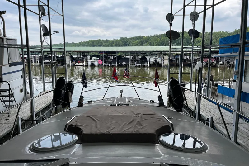 Slide: The Image of 2007 Regal 3760 IB COMMODORE yacht docked at marina with covered boats and lush greenery. - 12