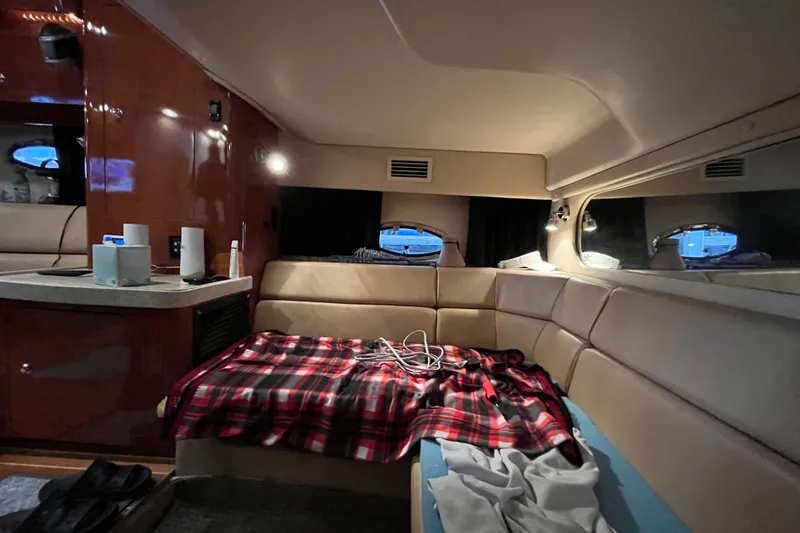 Slide: The Image of Interior of 2007 Regal 3760 IB Commodore yacht with cozy seating and plaid blanket. - 34
