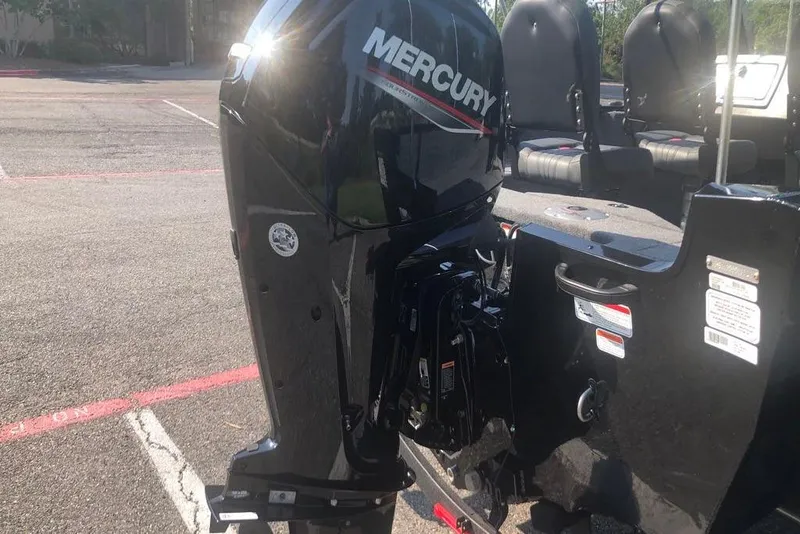 Slide: The Image of 2026 Tracker Pro Guide V-16 WT boat with Mercury outboard motor in parking lot. - 3